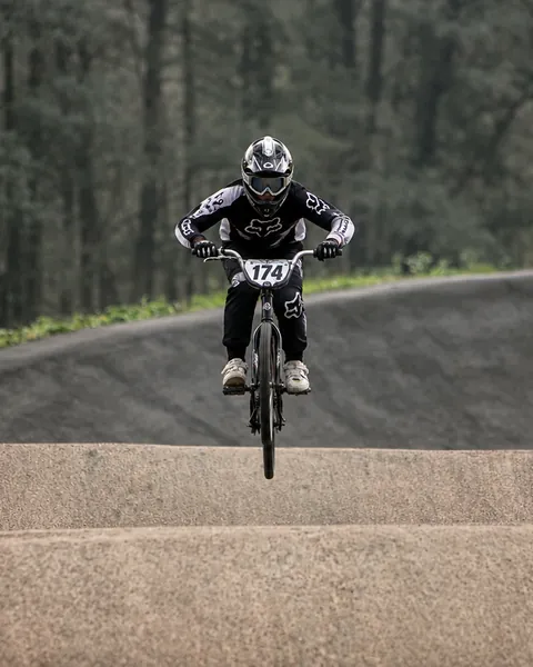Corredor de BMX en el aire sobre los saltos de una pista