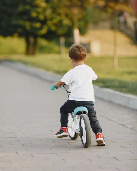Niño pequeño de espaldas aprendiendo en una bicicleta de balance